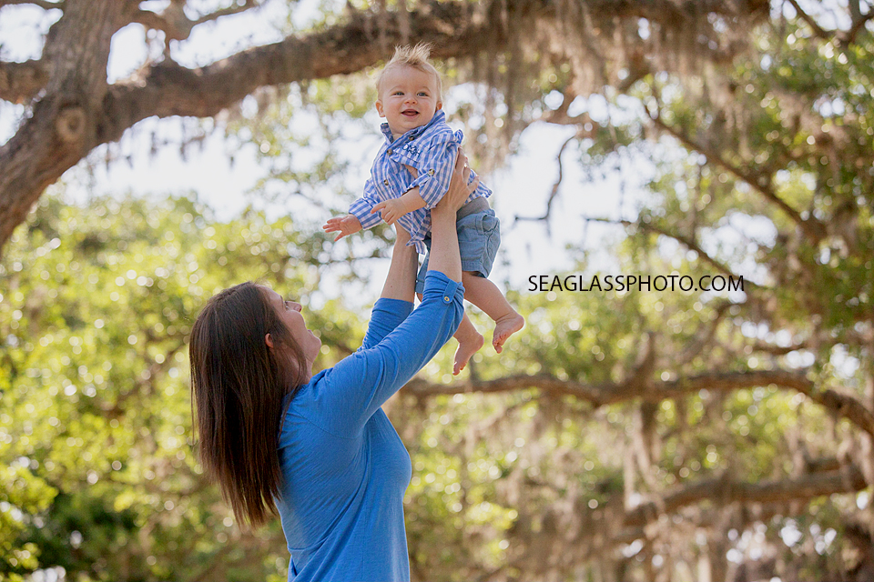 Mom holding up son while he laughs at Riverside Park in Vero Beach Florida