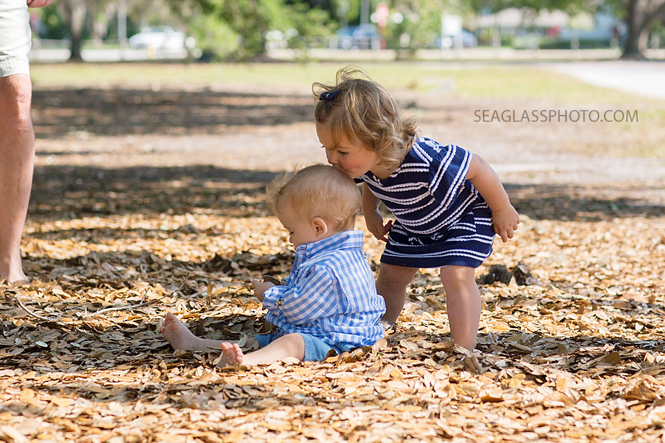 big sister kisses litlle brother on the head during family photo shoot at Riverside park in Vero Beach Florida
