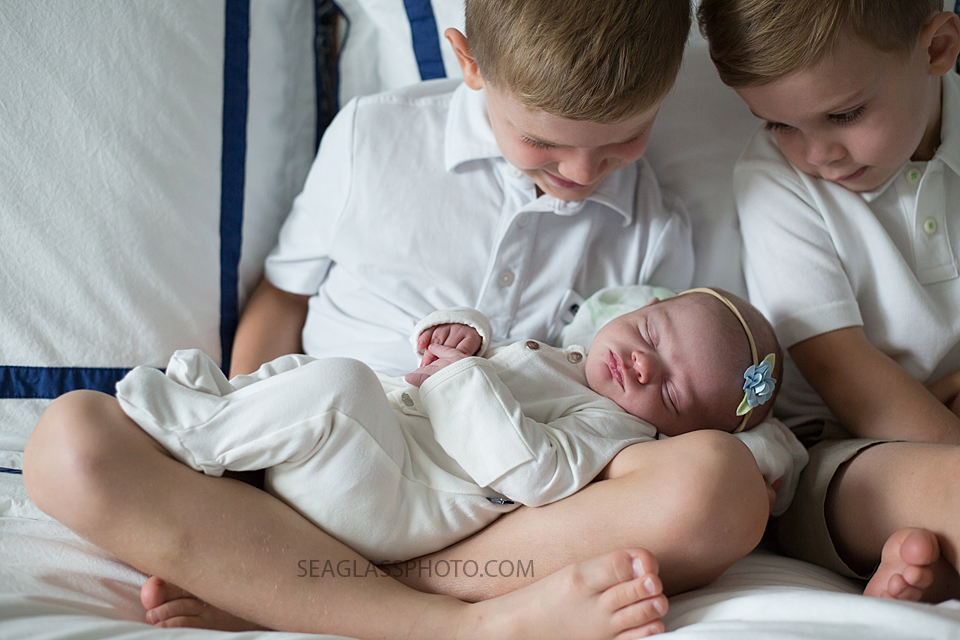 Close up of older brothers admiring their little sister during newborn shoot in Vero Beach Florida