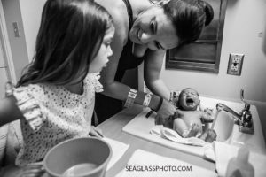 Mom gives her baby girl her first bath as her older sister watches in Vero Beach Florida