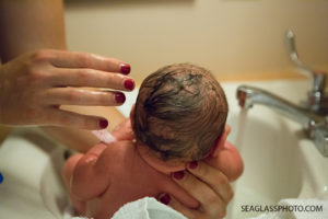 Close up of mom giving her daughter her first bath in Vero Beach Florida