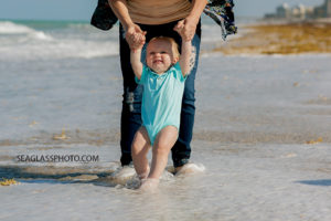 Close up of Mom and youngest son walking on the each in the water during family photos in Vero Beach Florida