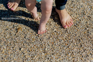 Close up of Mom and her youngests sons feet in the sand at the beach during family photos in Vero beach Florida