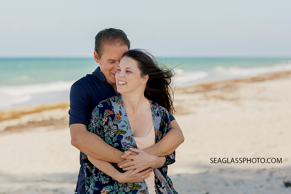 Husband tells his wife a joke during family photos on the beach in Vero Beach Florida