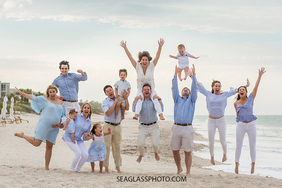 Family jumps with excitement during family photos on the beach at Johns island beach club in Vero Beach Florida