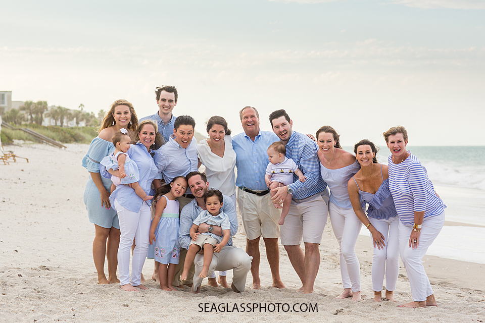 Family poses on the beach at Johns island beach club all matching during family photos in Vero Beach Florida