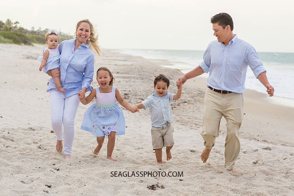 Family runs on the beach during family photos in Vero Beach Florida