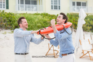 Brothers playing with a lifesaver on the beach at John islands beach club during family photos in Vero Beach Florida