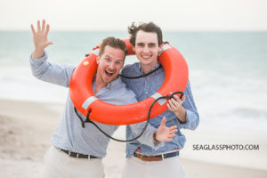 Close up of brothers posing with a lifesaver on the beach at Johns island beach club during family photos in Vero Beach Florida