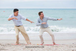 Brother in laws pretend to surf on land at johns island beach club during family photos in Vero Beach Florida