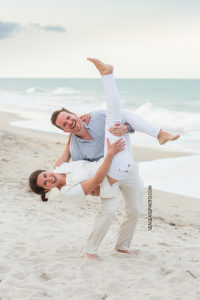 husband and wife mess around on the beach at johns island beach club during family photos in Vero Beach Florida