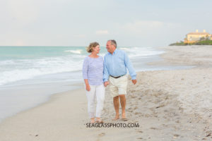 Husband and wife walk and talk on the beach at johns island beach club during family photos in Vero Beach Florida