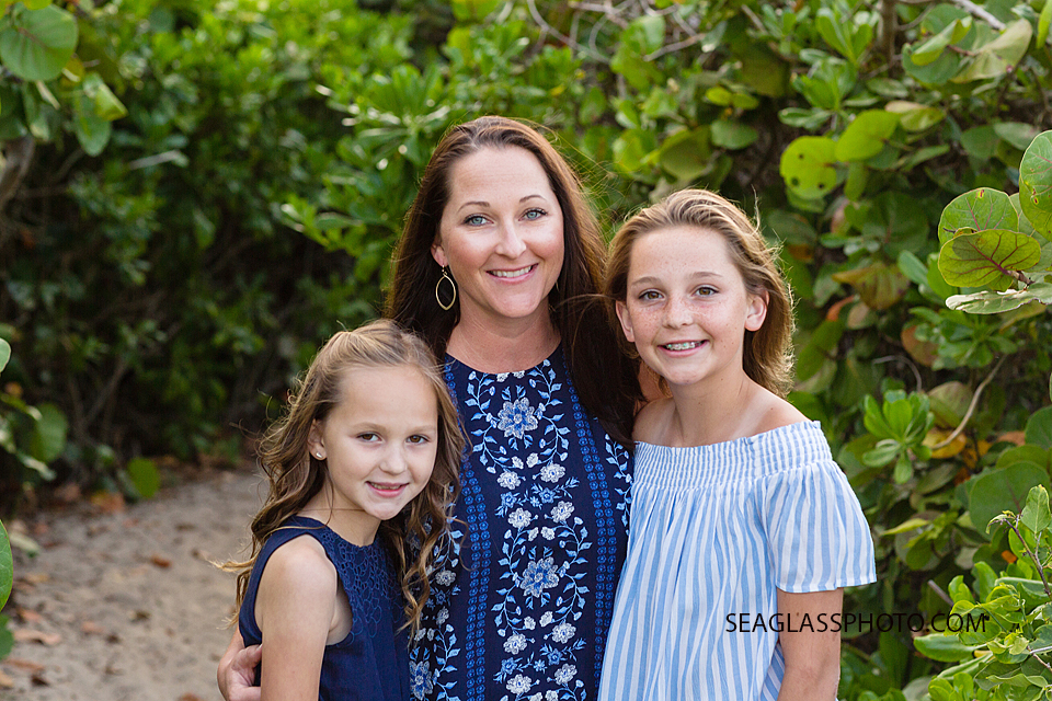 Mother and daughters smiling on the beach in front of sera grapes during family photo shoot in Vero Beach Florida