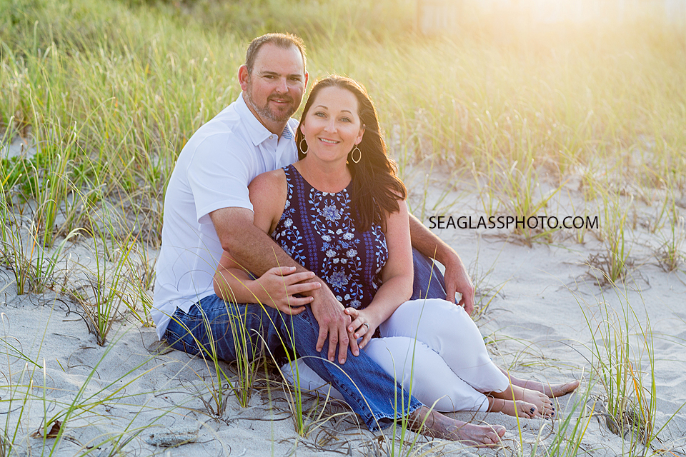 Mom and Dad posing by the dunes on the beach during family photo shoot in Vero Beach Florida