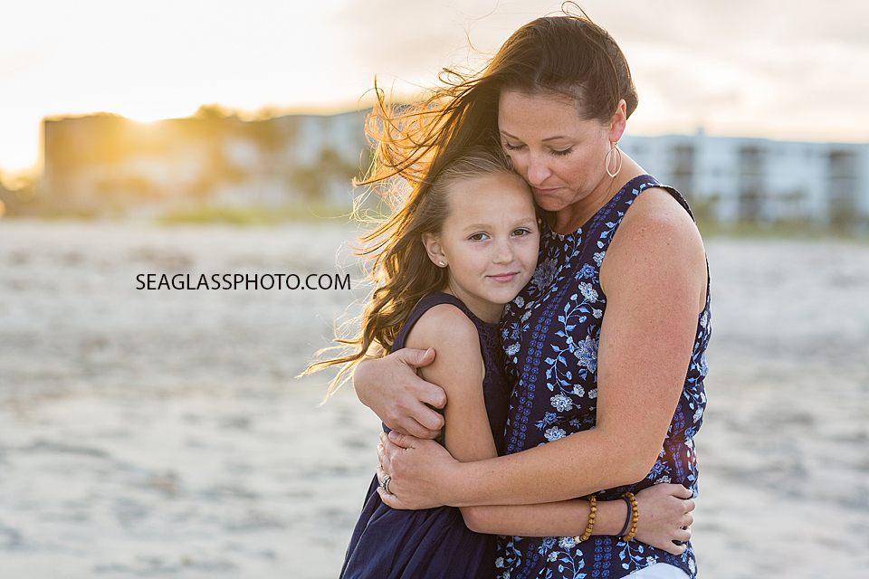 Mom hugging her youngest daughter on the beach in Vero Beach Florida