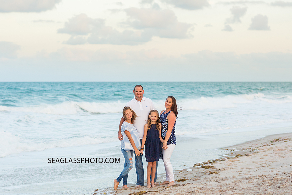 family standing in front of the ocean during family photos in Vero Beach Florida