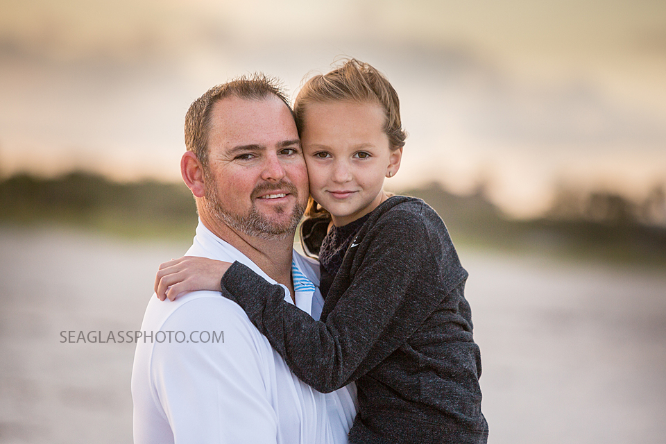 Close up of father holding his youngest daughter on the beach during family photo shoot in Vero Beach Florida
