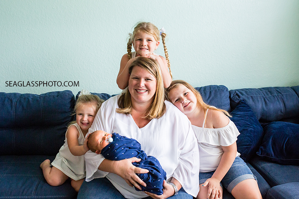 Mom poses in the middle of her four kids as the all smile during newborn shoot in Vero Beach Florida