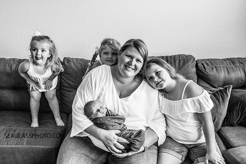 Black and white photo of mom and her four kids as they have fun during the newborn shoot in Vero Beach Florida