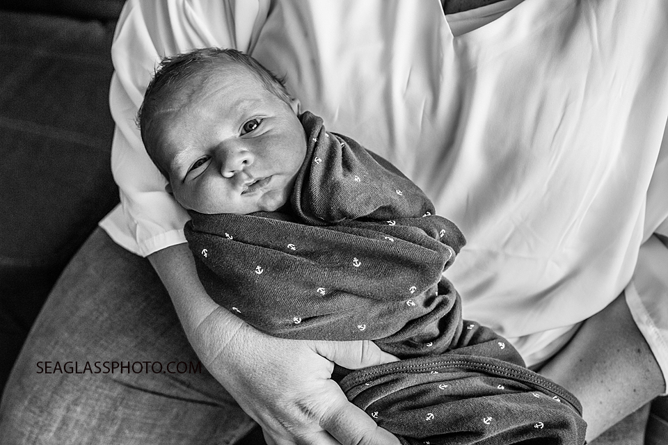 Black and white close up of newborn baby boy looking straight into the camera during newborn session in Vero Beach Florida