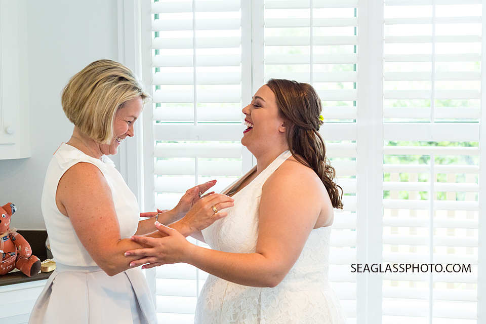 bride and mom joyfully laughing before the big moment in Vero Beach Florida