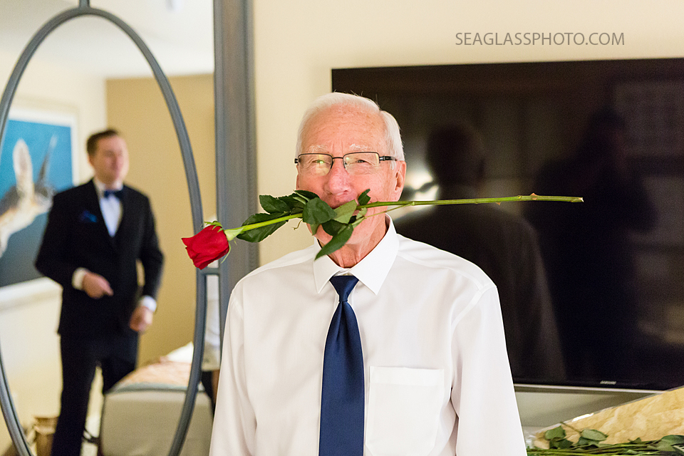 Groomsmen plays around with a rose before the wedding in Vero Beach Florida