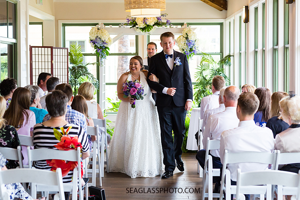 Bride and groom walk together after their wedding ceremony in Vero Beach Florida