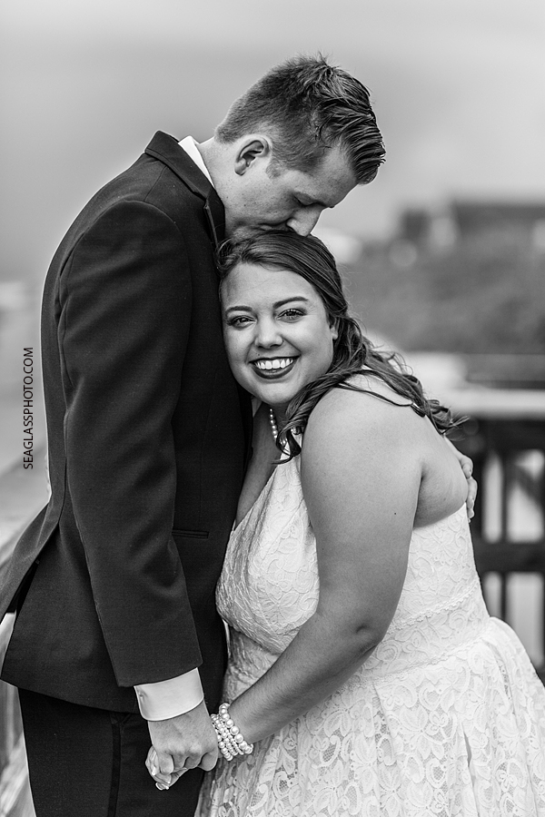 Black and white photo of groom kissing his bride after the wedding ceremony in Vero Beach Florida