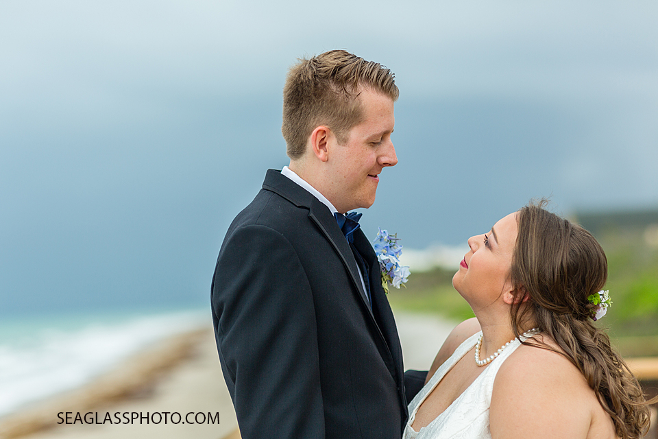 Bride and groom smile at each other on the beach after their wedding ceremony in Vero Beach Florida