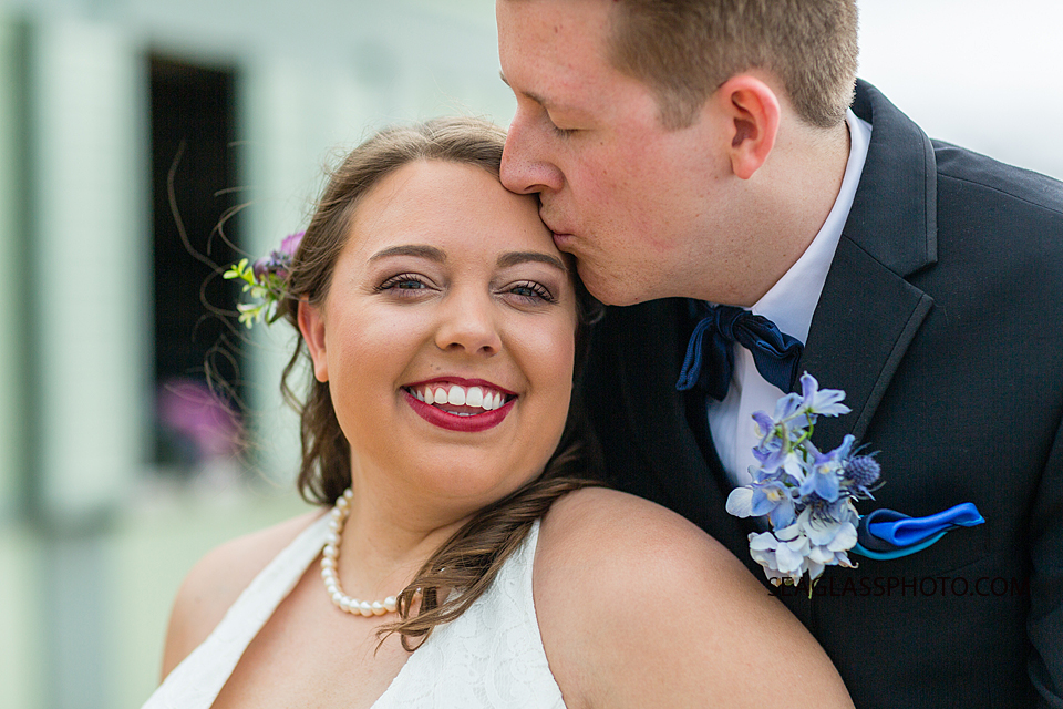 Close up of bride smiling as her husband kisses her on the forehead during wedding photo shoot in Vero Beach Florida