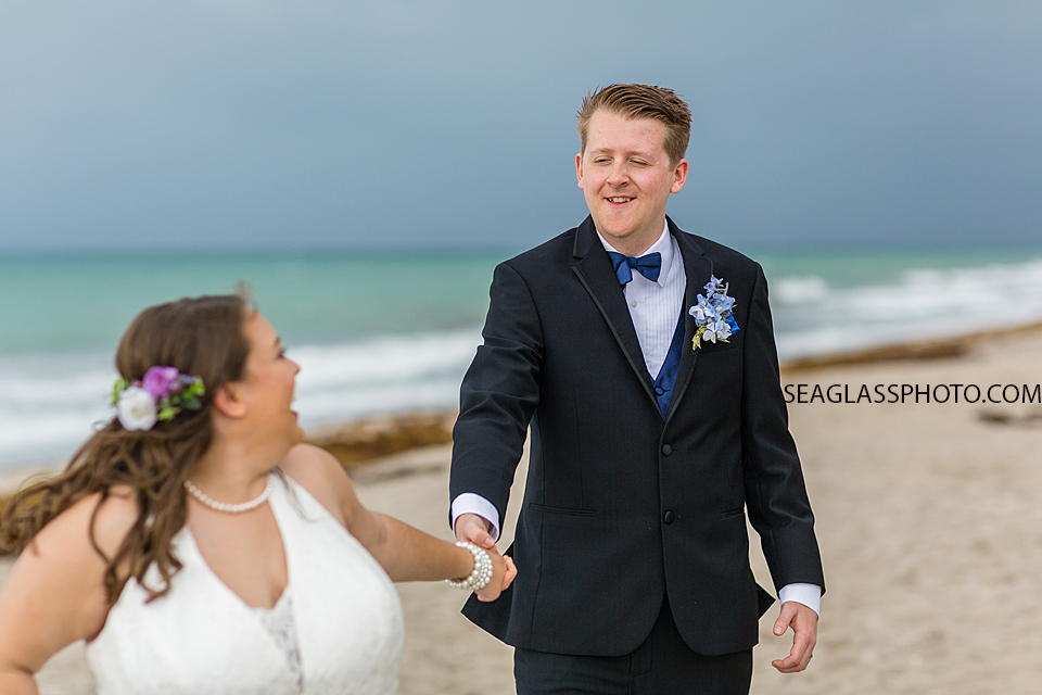 Close up of husband smiling at his wife as they walk on the beach during their wedding photo shoot in Vero Beach Florida