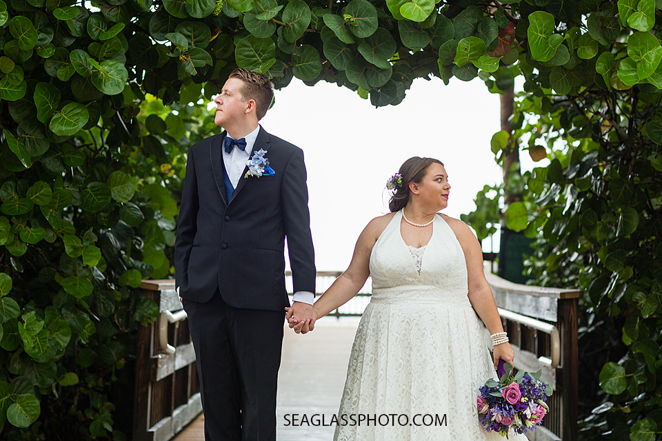 Bride and groom pose by sea grapes after their wedding in Vero Beach Florida