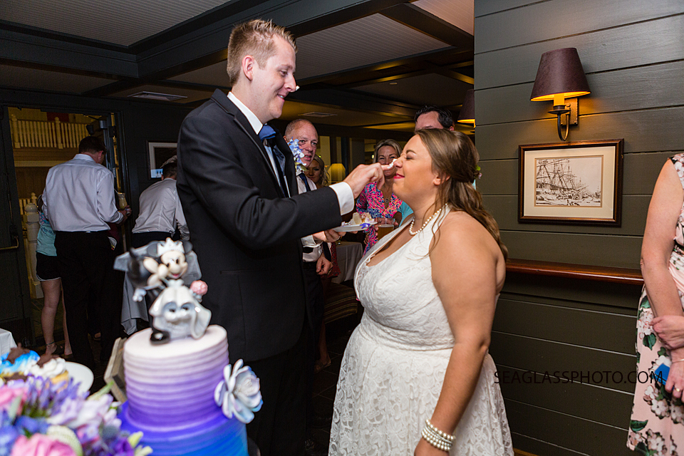 Bride and groom smear frosting on each other at their reception in Vero Beach Florida