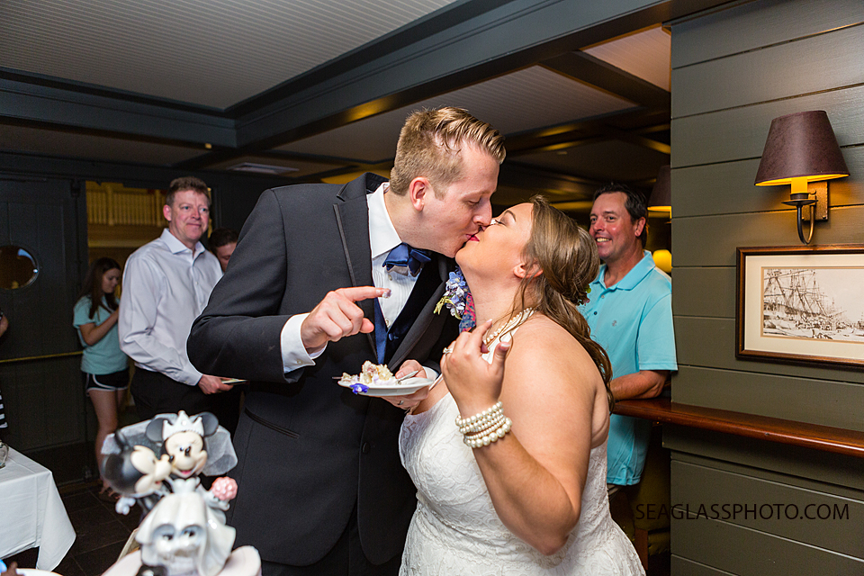 Bride and groom kiss after cutting the cake at the reception in Vero Beach Florida