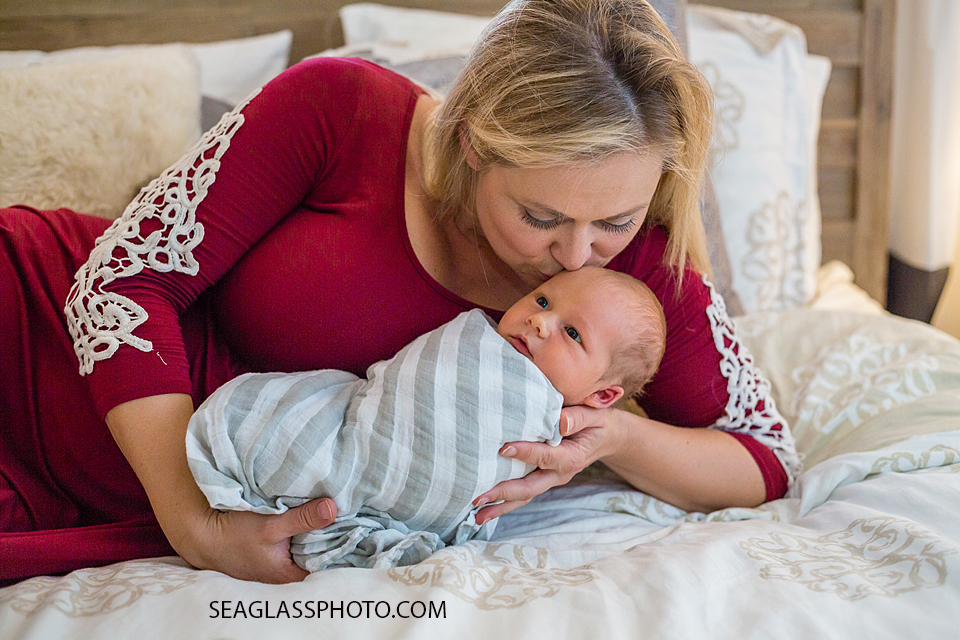 Mommy kisses new born son on the fore head during new born session in Vero Beach Florida
