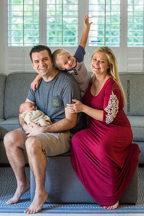 Family smiles with excitement as they hold their new born baby boy during new born shoot in Vero Beach Florida