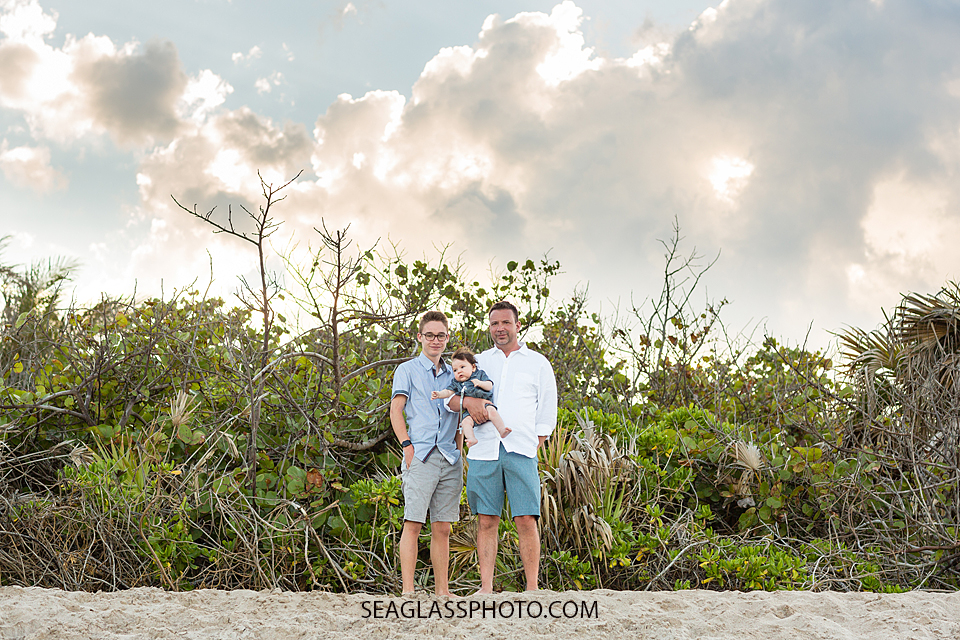 Father poses with his sons on the beach during family photo shoot in Vero Beach Florida