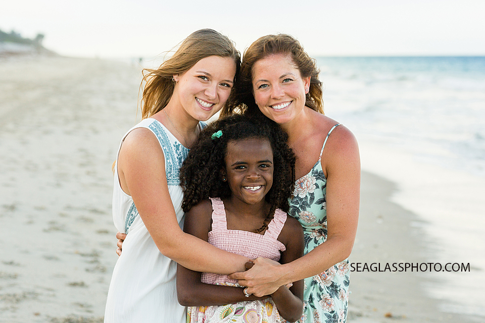 Mom poses withe her daughters on the beach during family photo shoot in Vero Beach Florida