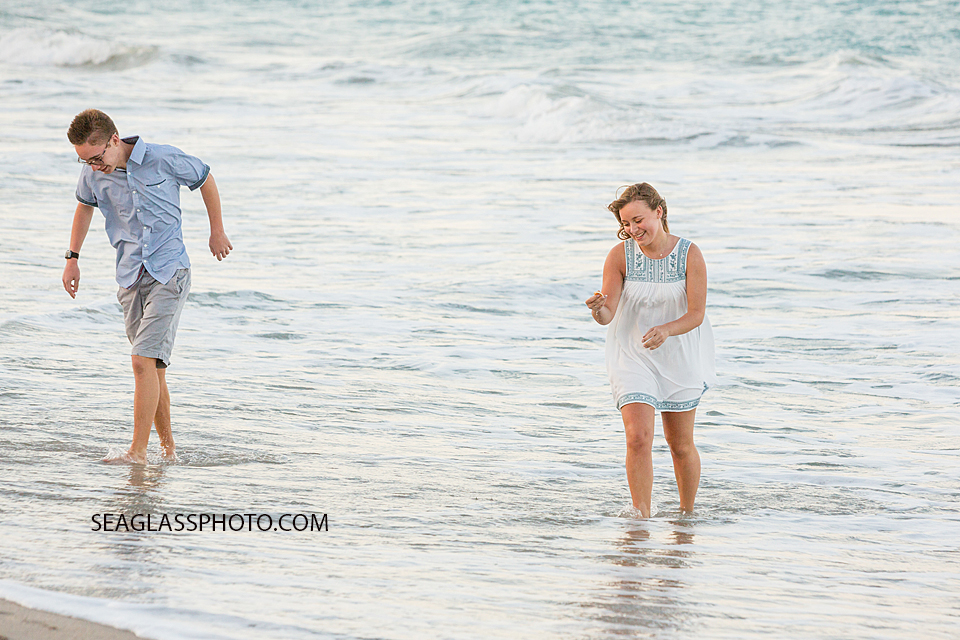 Oldest siblings walk in the water on the beach during family photo shoot in Vero Beach Florida