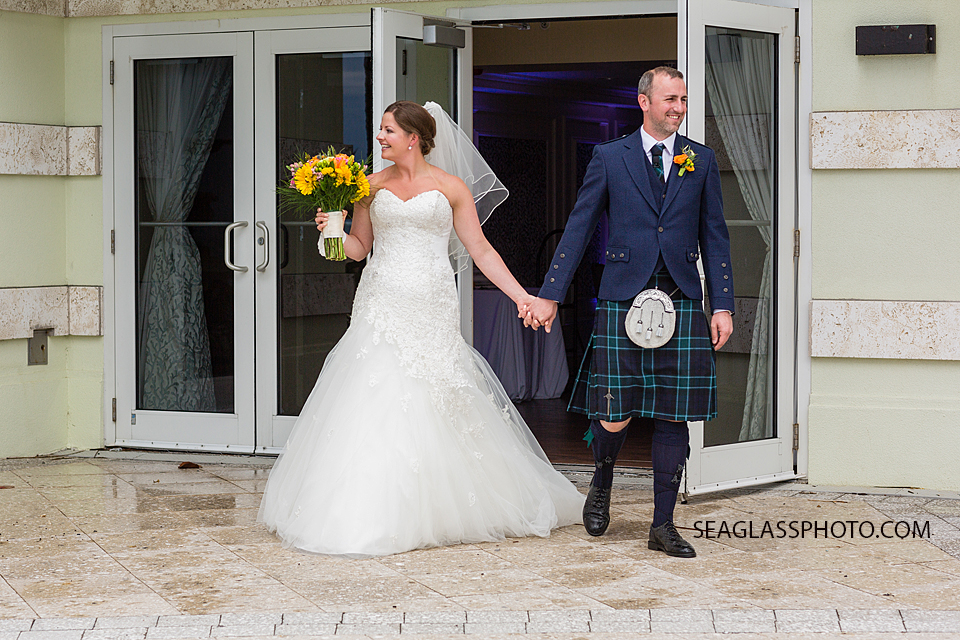 Husband and wife walk out after the ceremony at the Kimpton Vero Beach hotel and spa in Vero Beach Florida