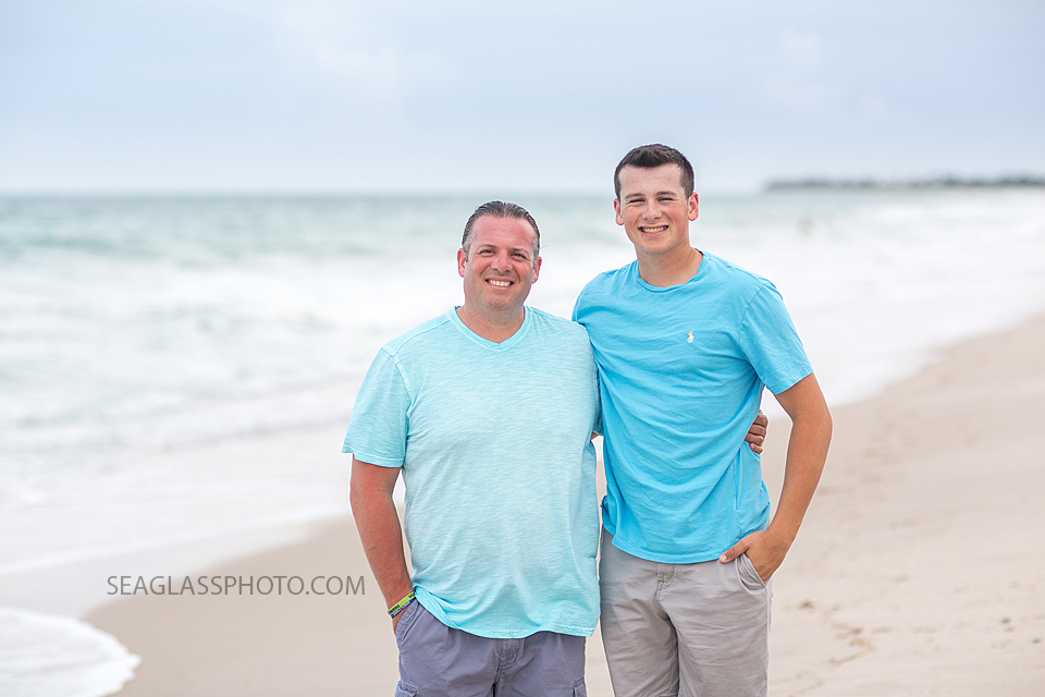 Father and son pose in front of the waves during their family photo shoot in Vero Beach Florida