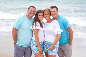 Family gets close together on the beach during their family photos in Vero Beach Florida