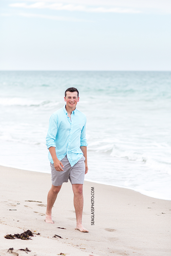 Soon to be senior walks on the beach for his senior pictures in Vero Beach Florida