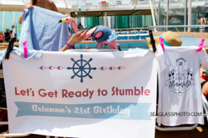 Family gets decorative outfits and banners to wear on the cruise of their family members twenty first birthday Photographed by a Vero Beach Florida Photographer