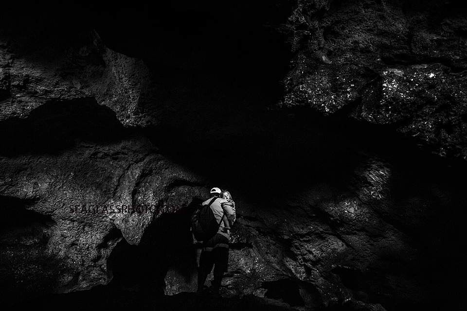 Black and white photo of a father carrying his daughter through a cave in the bahama's Photographed by a Vero Beach Florida Photographer
