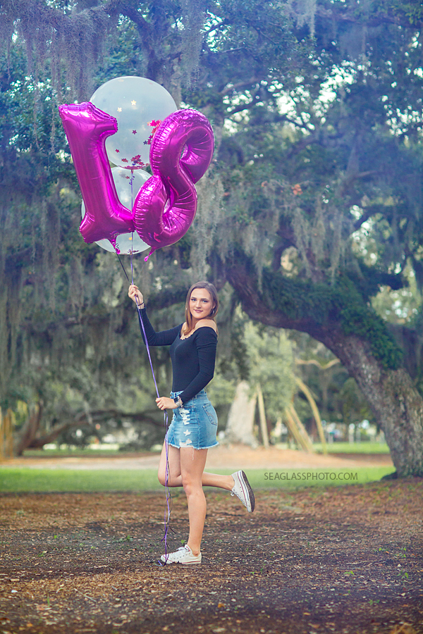 Young lady celebrates her eighteenth birthday with balloons on Riverside in Vero Beach Florida