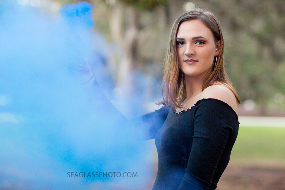 Close up of young lady posing with blue smoke for her senior/birthday pictures in Vero Beach Florida