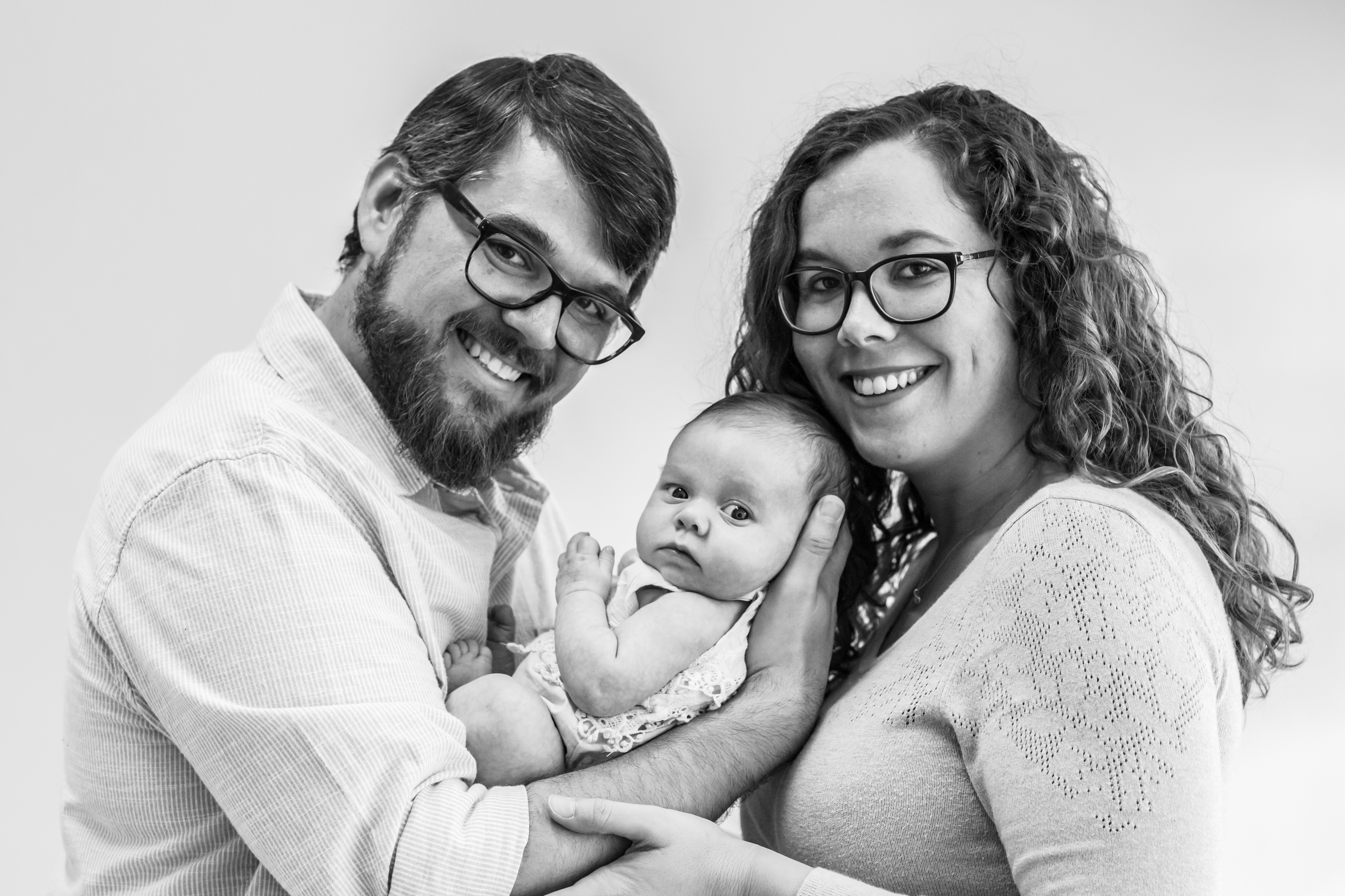 Black and white photo of parents holding their new born daughter during new born shoot in Vero Beach Florida