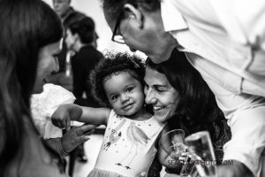 Black and white photo of a little girl getting lots of love during a 90th birthday celebration in Vero Beach Florida