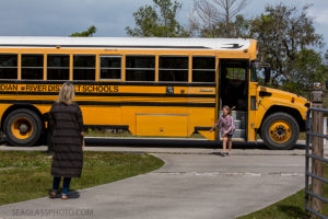 Daughter getting of the bus after school during a home photo shoot in Vero Beach Florida